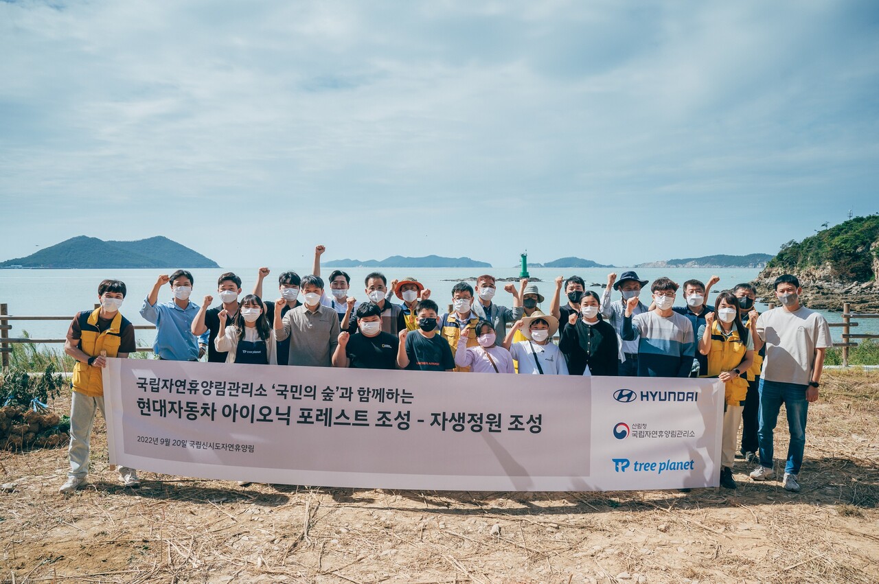 20일 전북 군산 국립신시도자연휴양림 인근 몽돌해변에서 진행된 자생정원(아이오닉 포레스트) 조성 행사에 참가한 현대차, 국립자연휴양림관리소, 트리플래닛 임직원 및 지역 초등학생들이 기념사진을 촬영하는 모습