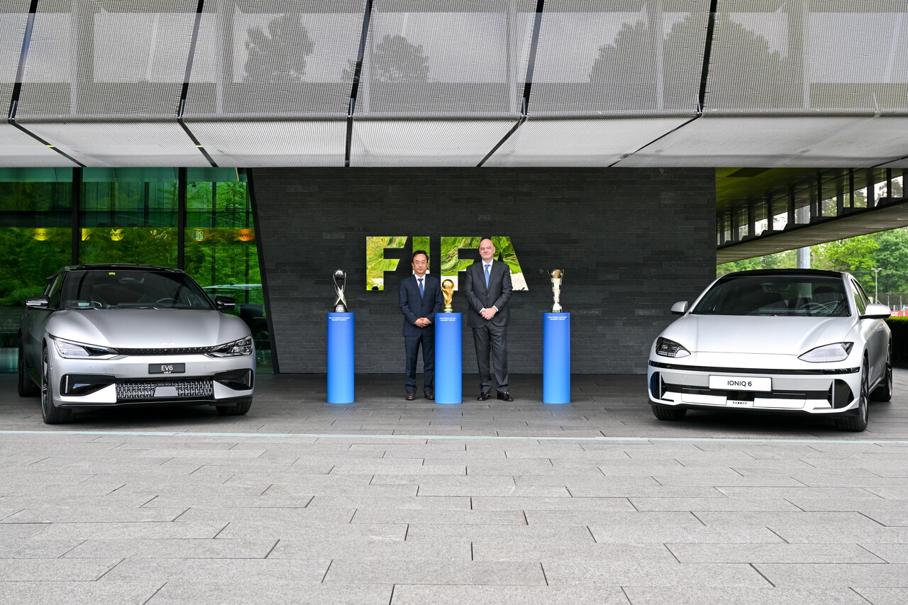 현대자동차그룹 기획조정실장 김걸 사장(왼쪽)과 지안니 인판티노(Gianni Infantino) FIFA 회장(오른쪽)이 조인식 이후 아이오닉 6, EV6 옆에서 기념 촬영을 하는 모습 